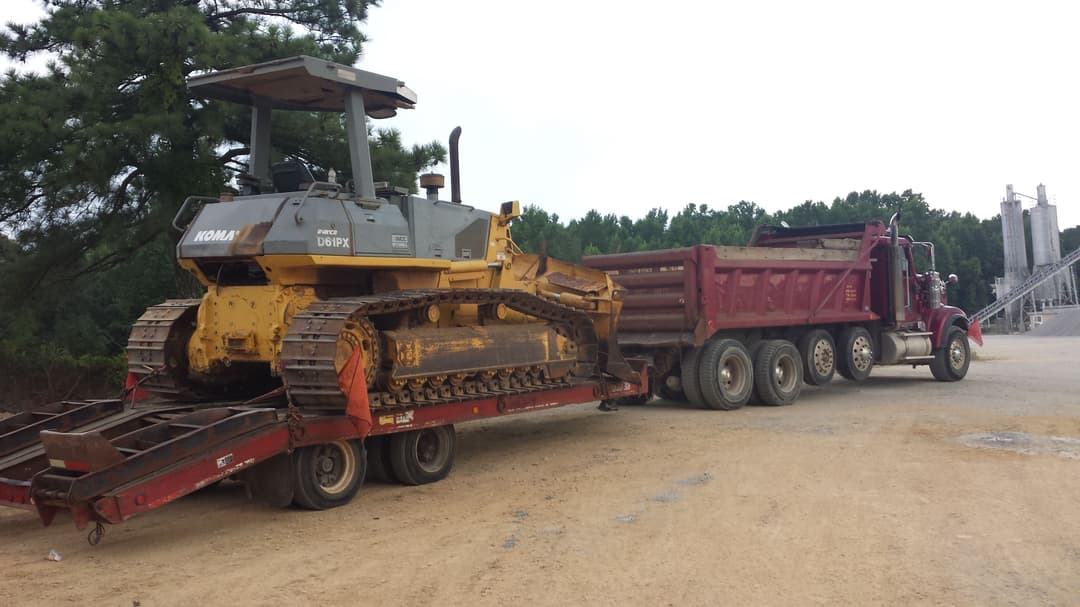 One of Granddaddy’s old dump trucks and his Komatsu dozer — tools that built a lifetime of memories, jobs, and lessons that still shape how I run my business today