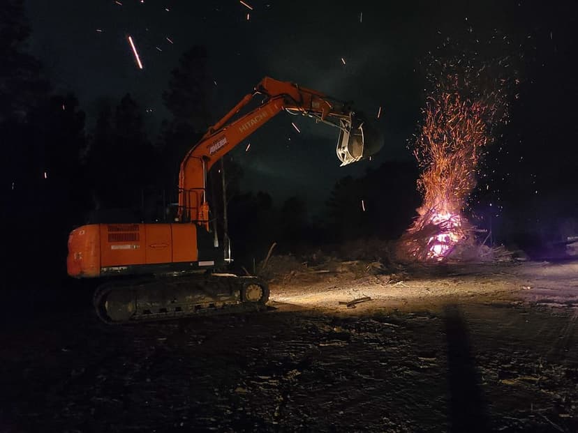 Excavator near a fire at night