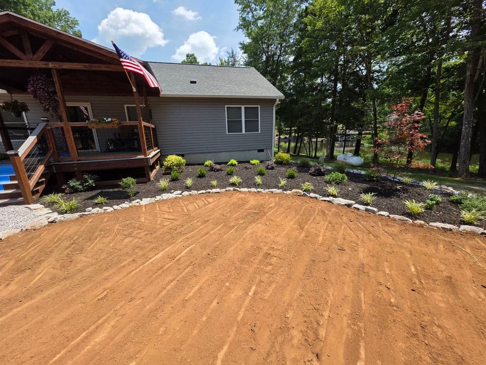 Home exterior featuring landscaped garden with shrubs, mulch, and a porch with an American flag.