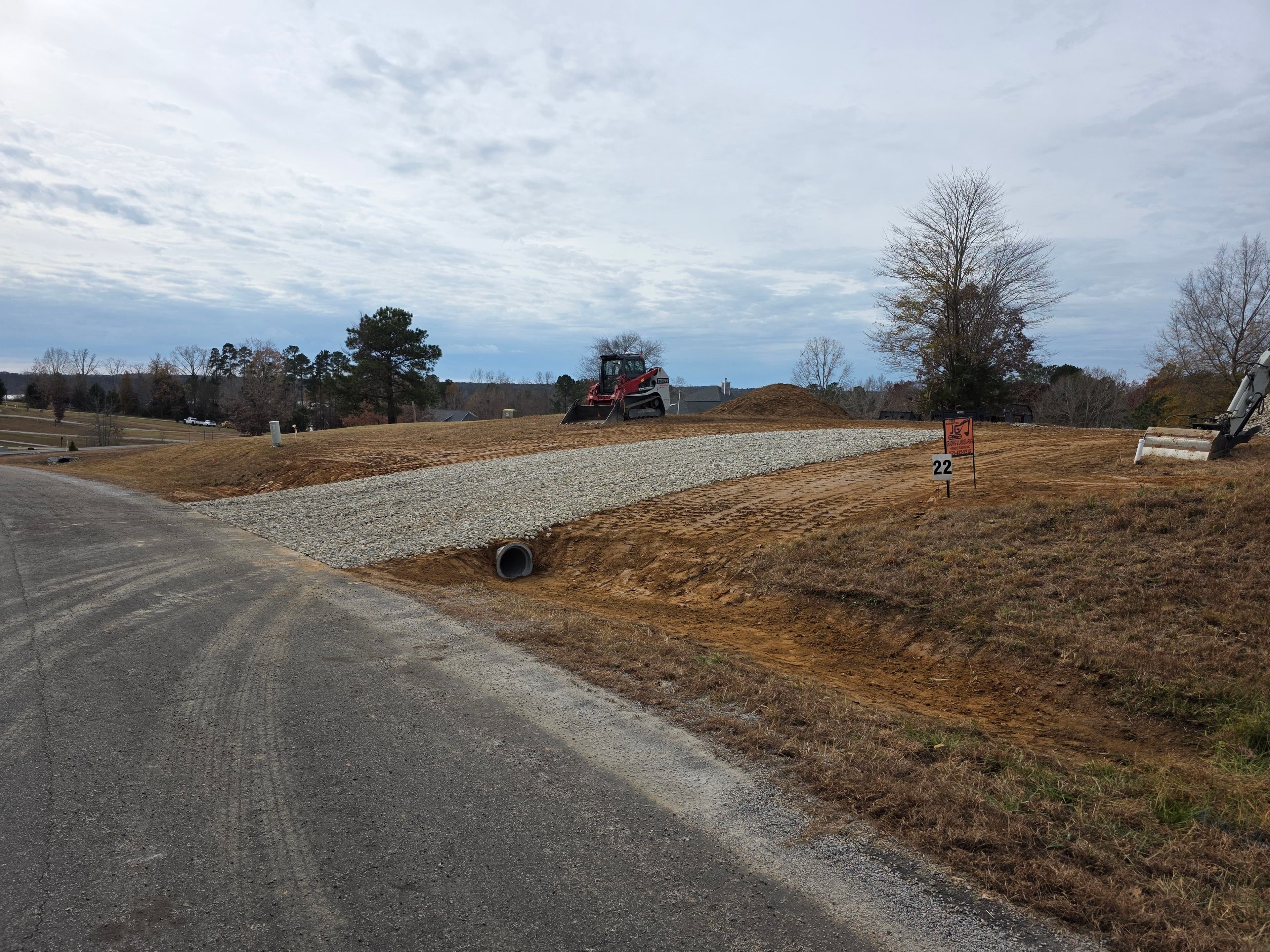 Construction site with gravel pathway and machinery, showcasing road development progress.