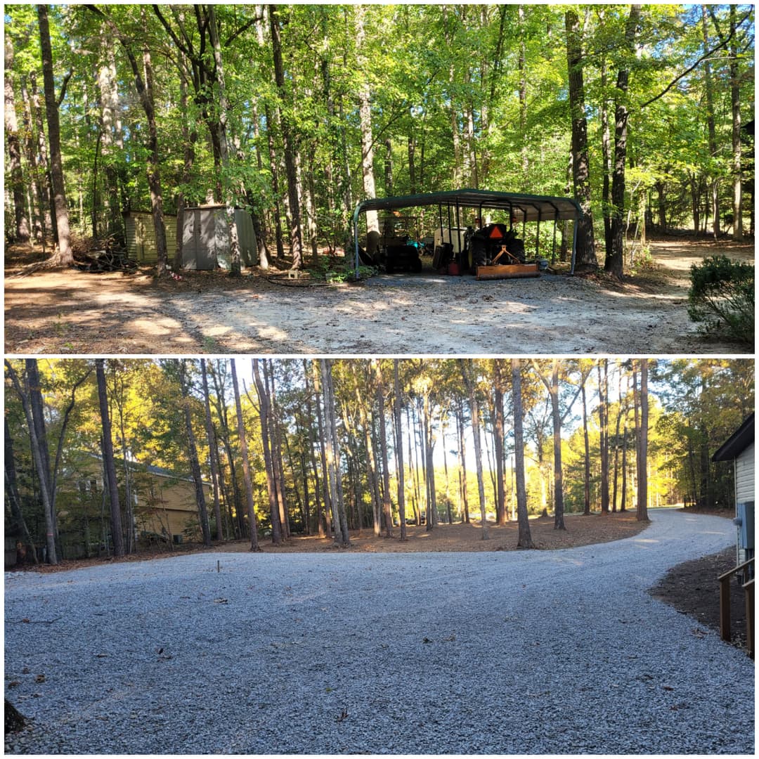 Gravel driveway and shaded outdoor structure in a wooded area. Lush green trees in background.